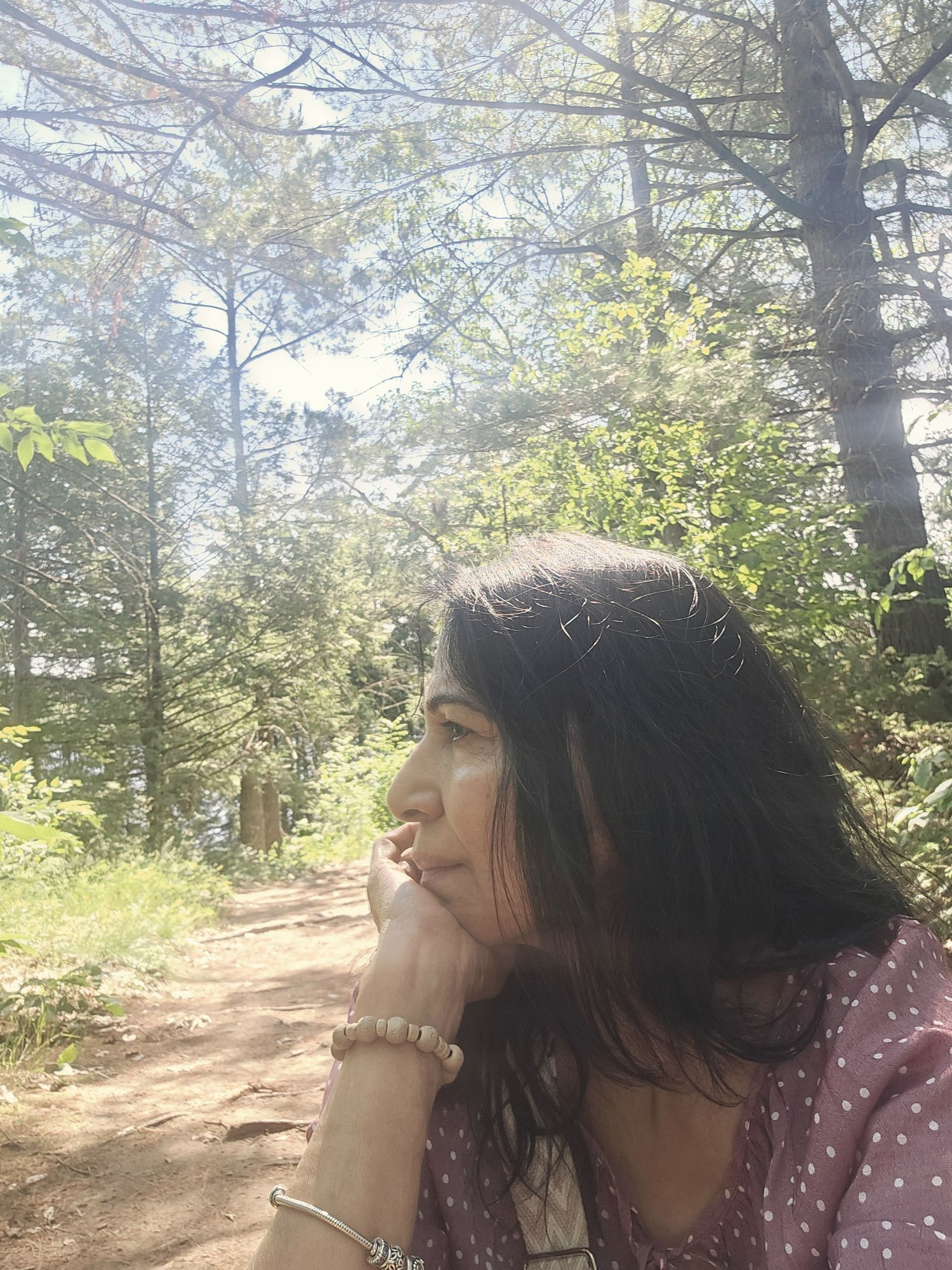 Neetu in quiet reflection on a wooded trail
