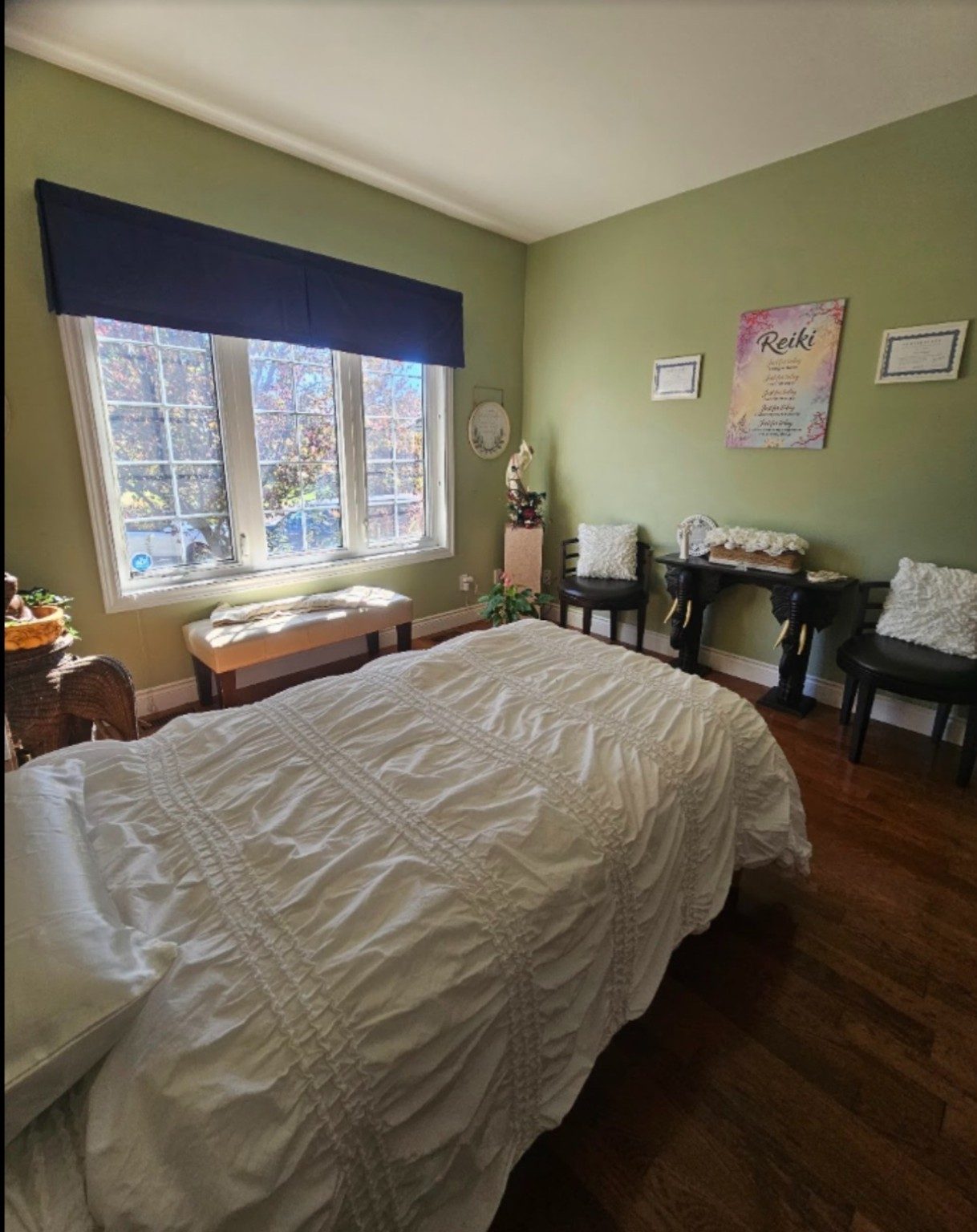 Neetu's private home Reiki studio in Whitby, with a Reiki wall hanging and framed certifications