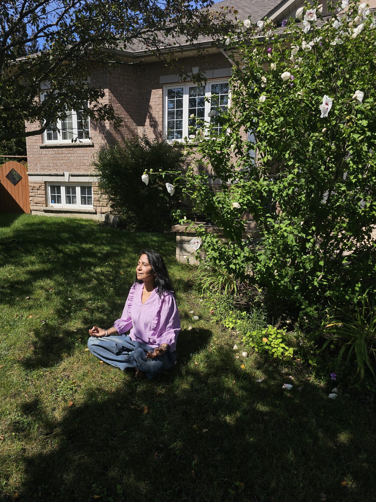 Neetu meditating peacefully in a sunlit garden